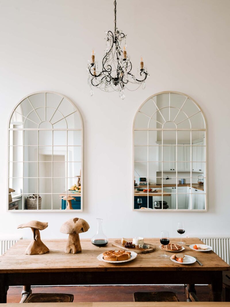 Kitchen table with arched mirrors on wall